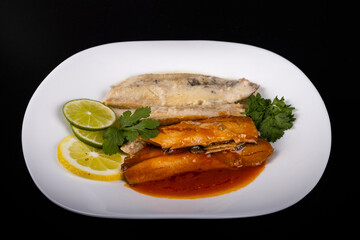 herring fillets on a plate with two kinds of sauce with lemon and lime