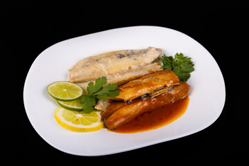 herring fillets on a plate with two kinds of sauce with lemon and lime