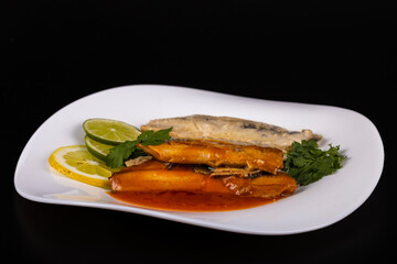 herring fillets on a plate with two kinds of sauce with lemon and lime