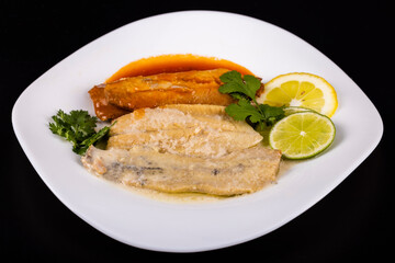 herring fillets on a plate with two kinds of sauce with lemon and lime