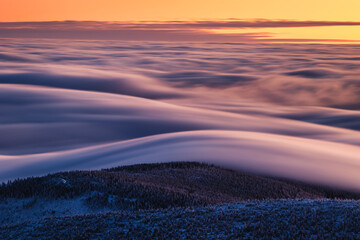 Winter morning on Śnieżka in the Karkonosze Mountains, colorful dawn heralds a beautiful day.