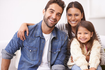 Fototapeta premium They treasure each other. Portrait of a happy young family sitting together at home.