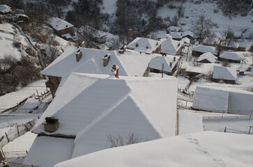 Top view of snow covered roofs of hillside houses in Bulgaria