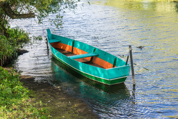 Naklejka na ściany i meble Rowing boat floating over the Lake. Fishing lake in early summer.