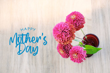 Mother's day background with pink zinnia flowers on wood from top view.