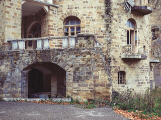 A fragment of an old overgrown and dilapidated castle-style building on an autumn day. Ancient historical landmark of the Caucasus