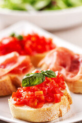 Italian appetizer bruschetta with Parma ham on a plate