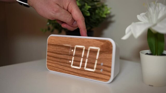 A close up view changing a common household desk clock one hour forward for Daylight Saving Time.  	