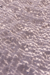 Shade from a sunshade on the sand at the beach background