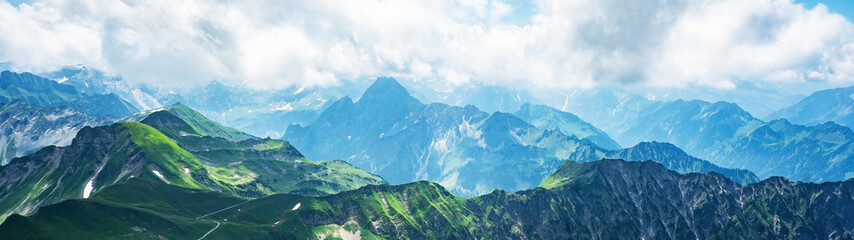 Panoramic view from Nebelhorn in Oberstdorf Allgäu Bavaria Germany - Beautiful Alps with lush green meadow and blue sky - Mountains landscape background banner panorama