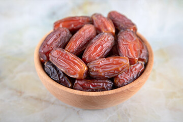 Bowl of dates fruit on colorful marble background, top view