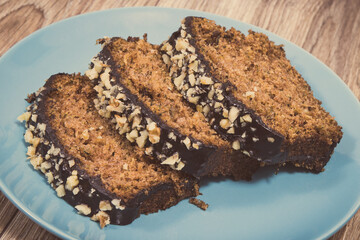 Homemade pastry made of zucchini with nuts and raisin on blue plate. Wooden background