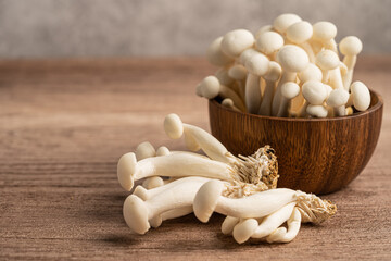 Shimeji, Fresh white bunapi mushrooms from Asia in wooden bowl.