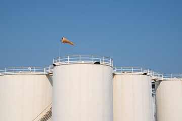 Petroleum oil storage tank with wind socks with blue sky. Industrial petroleum plant. Base oil for...