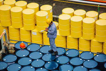 Male worker inspection record drum oil stock barrels yellow vertical or chemical for transportation...