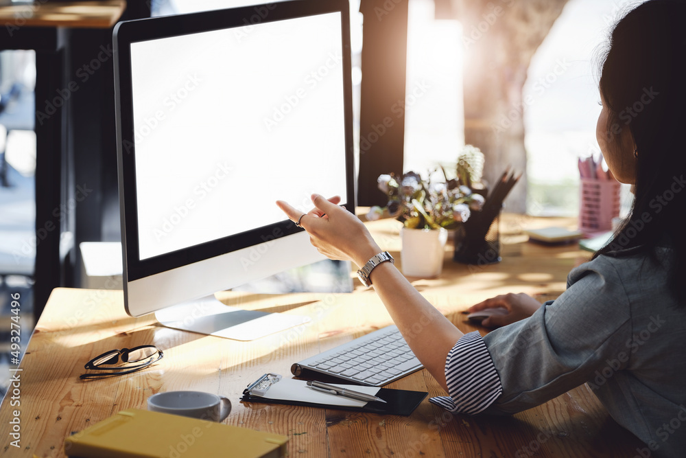 Poster a woman pointing at a computer with a blank white screen. the blank space on the white screen can be