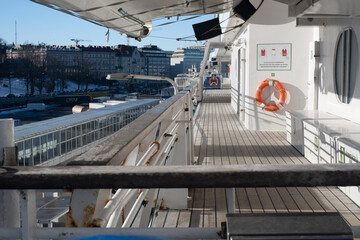 Closeup of a liferaft of a large passeger ferry. An outside walking promeade of a cruise ship.