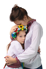 The mother hugs the child with tearful eyes. A child in Ukrainian national clothes.