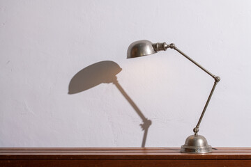 Vintage design Jielde lamp on a cabinet against a white wall. Copy space. High quality photo