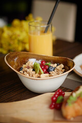 Dry breakfast with fresh berries,orange juice on background.Healthy meal,vertical photography.