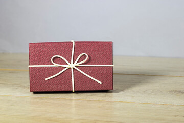 Christmas gift box with knot on wooden table 