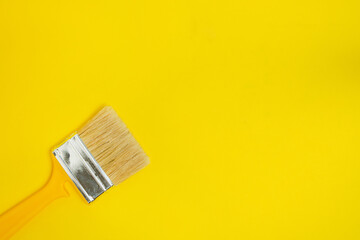 Paint brush for painting and repair on a yellow background.