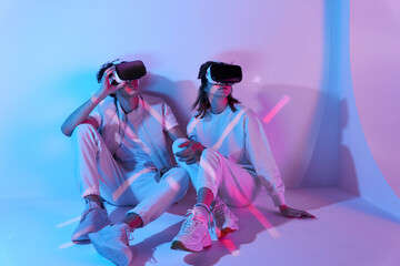 Couple in VR headset sitting near wall