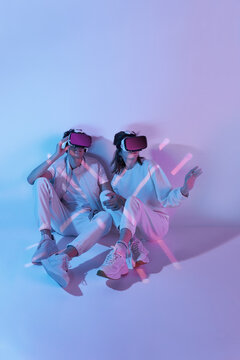 Couple in VR headset sitting near wall