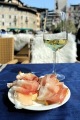 Ein Glas Weißwein und kleine Schinkenbrötchen in Trento, Italien