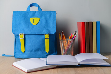 Stylish backpack and stationery on table
