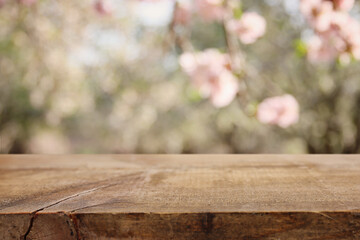 wooden table in front of spring blossom tree landscape. Product display and presentation