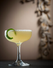 Pale Yellow Cocktail with Green Garnish in Champagne Coupe Glass