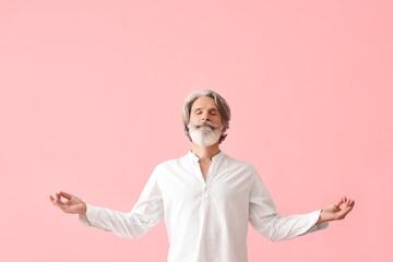Meditating mature man on color background - obrazy, fototapety, plakaty