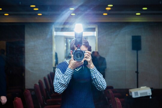 Photographer in a suit takes a picture of himself in the mirror 
