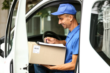 Male courier of delivery company with parcel in automobile