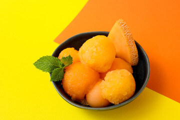 Bowl with tasty melon sorbet on yellow background - obrazy, fototapety, plakaty