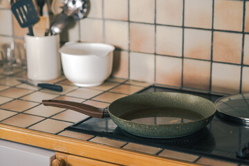 Greasy and oily cooking pan resting on a cooking surface from gl