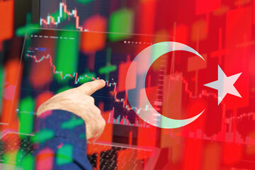 Turkey downtrend of the economy in a world crisis. Man hand shows on the decreasing candle stick...