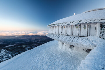 Winter view of the Meteorological Observatory on Śnieżka in the Karkonosze Mountains. The beautiful light of the rising sun creates an amazing atmosphere
