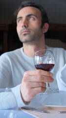 Man drinks wine in minimal luxury restaurant in hotel for summer time. 