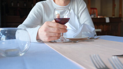 Man drinks wine in minimal luxury restaurant in hotel for summer time. 