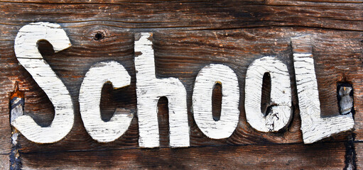 Carved Letters Spell School on Wooden Sign