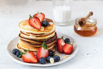 Pancakes with berries and honey. Delicious weekend breakfast