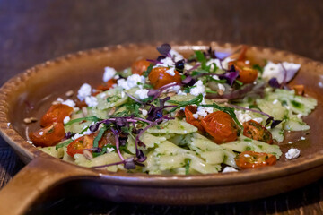 Farfalle pasta with wild garlic pesto dried cherry tomatoes and feta cheese for menu in restaurants