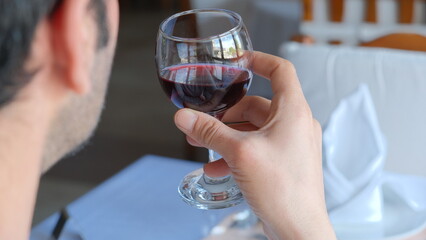 Man drinks wine in minimal luxury restaurant in hotel for summer time. 