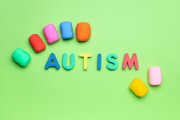Word AUTISM with plasticine on green background