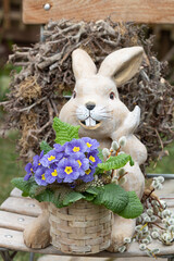 Osterdekoration mit blauer Primel und Osterhase