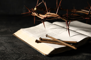 Crown of thorns with Holy Bible and nails on dark background