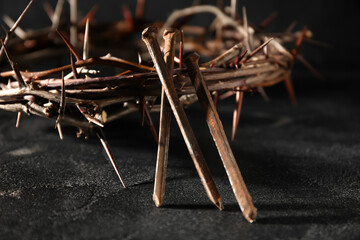 Crown of thorns with nails on dark background, closeup