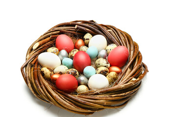 Nest with painted Easter eggs on white background